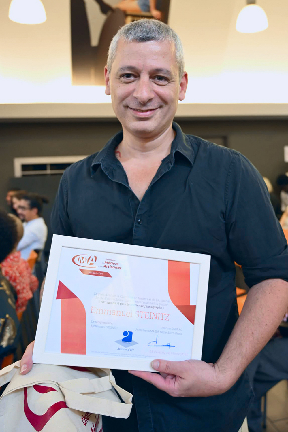 Emmanuel Steinitz tenant son diplôme de qualité d’Artisan d’Art Photographe à la CMA de Bobigny.