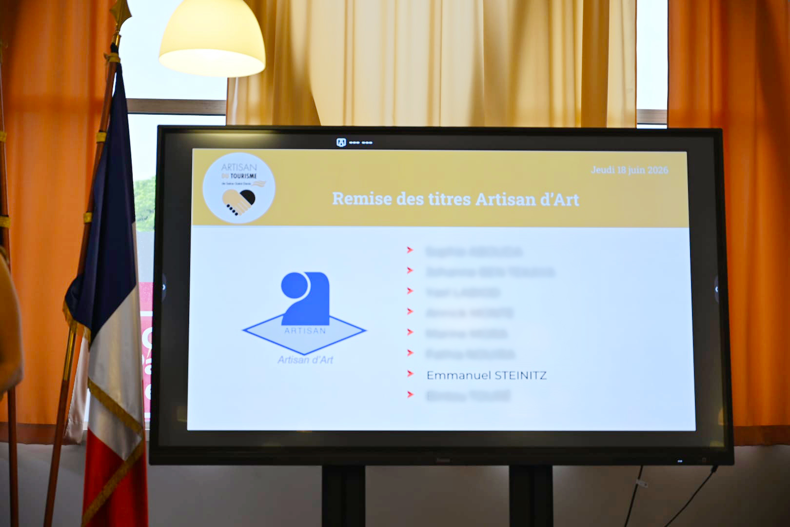 Écran de cérémonie présentant la remise de la qualité d’Artisan d’Art à la CMA de Bobigny en 2026.